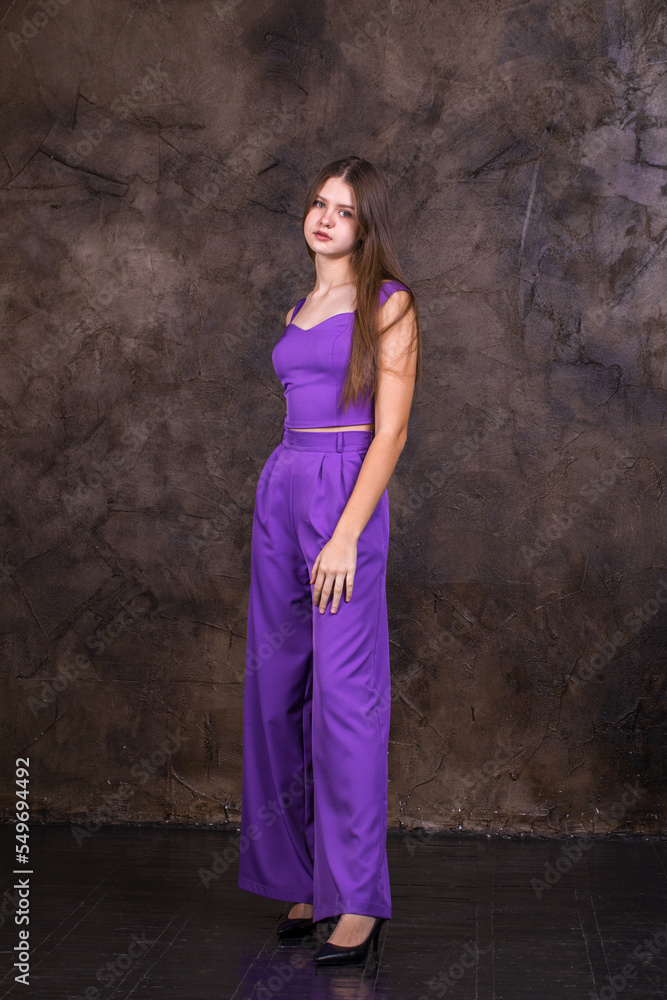 Portrait of a young beautiful brunette girl in purple pantsuit Portrait of a young beautiful brunette girl in purple pantsuit