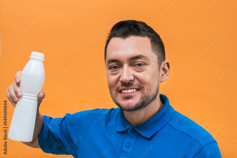 Handsome man with yogurt or milk on orange background. Mock up copy space Handsome man with yogurt or milk on orange background. Mock up copy space