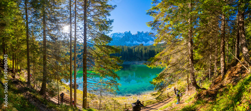 Amazing nature landscape. Lago di Carezza lake or The Karersee with reflection of mountains in the dolomite alps, Dolomites, Tyrol, Italy. Concept of ideal resting place. Popular travel destination. photo