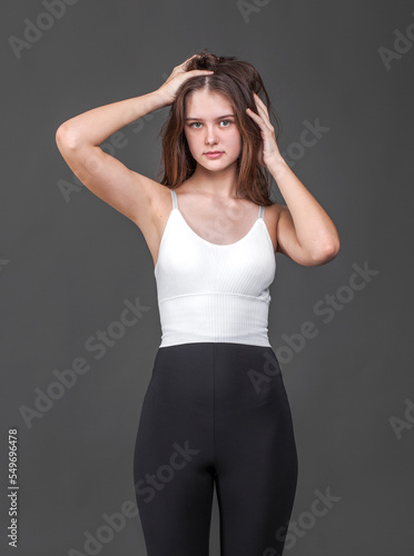Portrait of a young brunette woman, isolated on gray background © Andrey_Arkusha