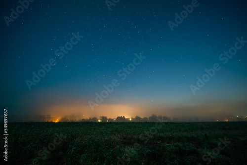 Starry night sky and fog over the city