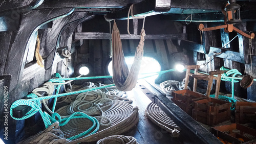 Ship interior with a coil of thick rope, hammock