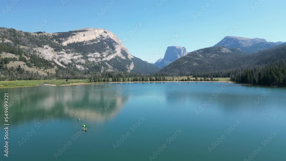 Boating On Still Waters With Mountain Peak Background In Green River Lakes, Wyoming. Aerial Drone Shot Boating On Still Waters With Mountain Peak Background In Green River Lakes, Wyoming. Aerial Drone Shot