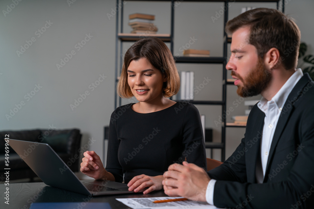 Smiling businesswoman and pensive businessman in formal wear working together