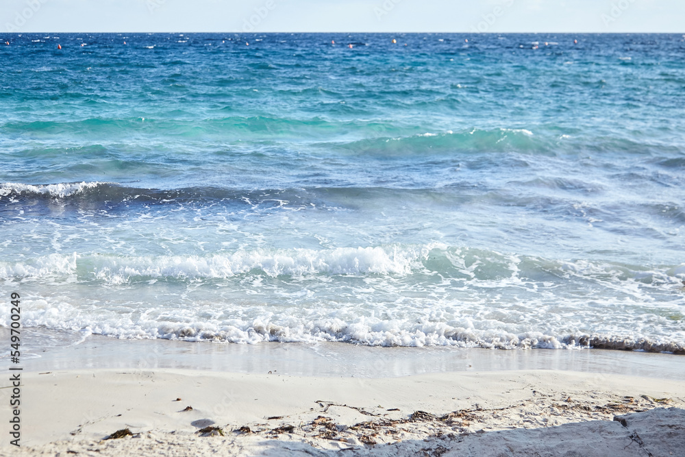Sand beach, summer sea with blue sky. Sea water with white wave. Cala azzurra beach, Favignana island, Trapani, Sicily, Italy. A beautiful seascape