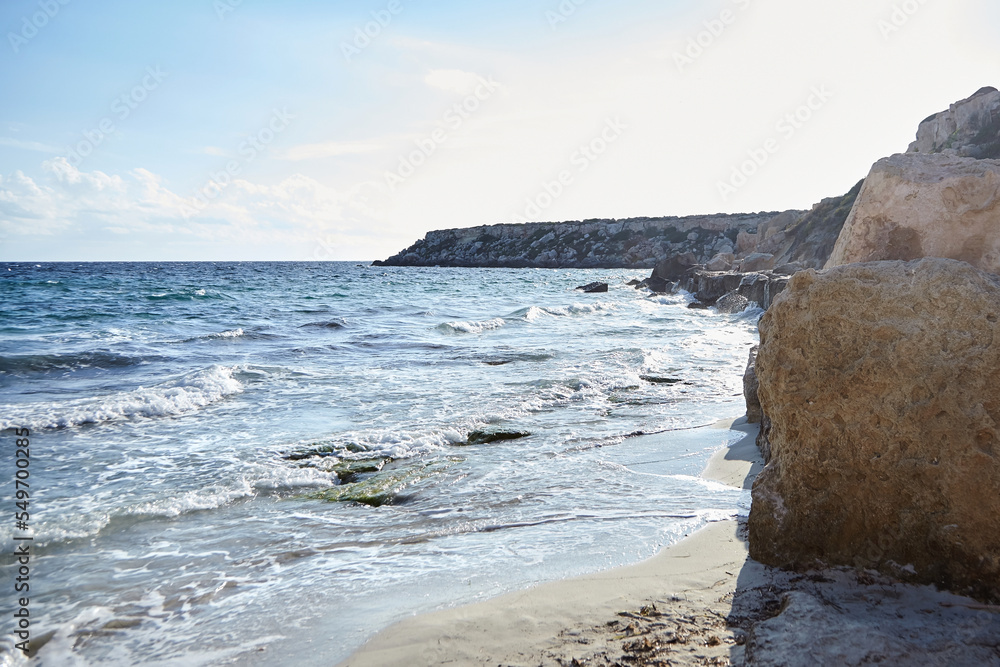 Sand beach, summer sea with blue sky. Sea water with white wave. Cala azzurra beach, Favignana island, Trapani, Sicily, Italy. A beautiful seascape