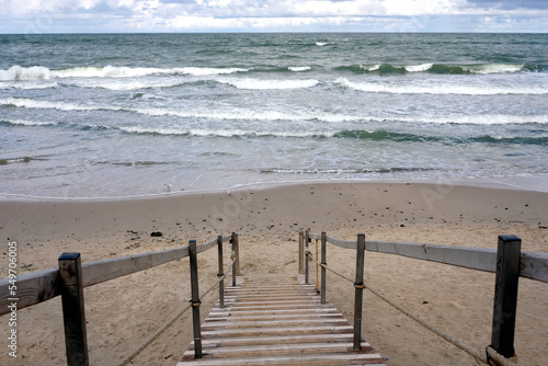 Landscape with empty sandy sea beach  sea and long stairs going to the coastline