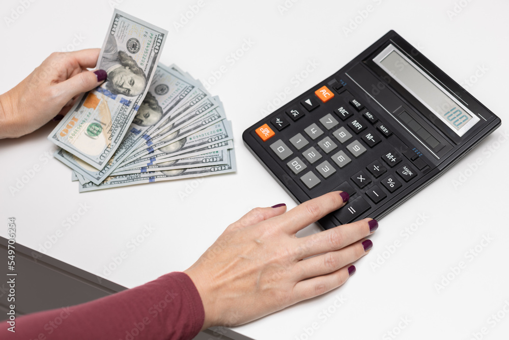 man counting dollars using an old calculator man counting dollars using an old calculator