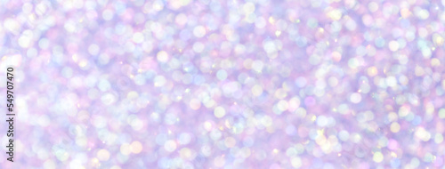 Blurred light purple and violet sparkling background from small sequins, macro. Lilac defocused backdrop