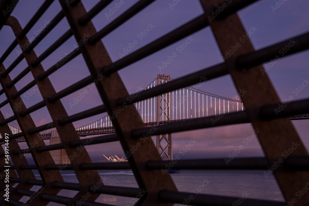 Obraz premium Oakland bay bridge California taken through the railing of Pier 14. High-quality photo was taken at blue hour