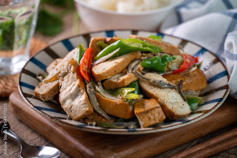 Homemade stir-fried dried beancurd with dried fish and green chili. Homemade stir-fried dried beancurd with dried fish and green chili.