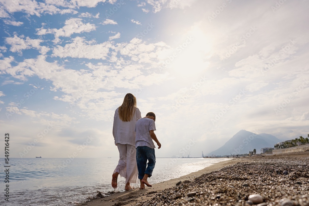 mother and son walking on sunset beach. High quality photo mother and son walking on sunset beach. High quality photo
