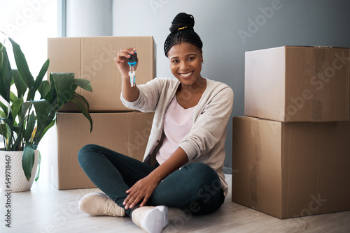Boxes, black woman and homeowner with keys, to new home and happiness in home. Property, African American female and lady moving into house, happy and content with apartment, excited and portrait. photo