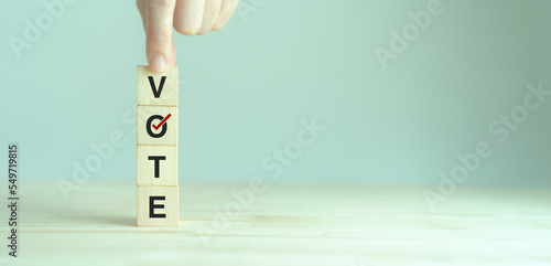 Election vote concept. Vote word with checkmark symbol on wooden cube blocks. Political election campaign logo. Applicable as part of badge design. Voting symbols design. Elections and poll icons.