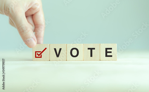 Election vote concept. Vote word with checkmark symbol on wooden cube blocks. Political election campaign logo. Applicable as part of badge design. Voting symbols design. Elections and poll icons.