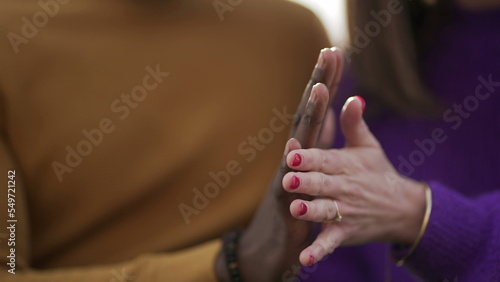 Diverse hands together. Close-up black man and white woman holding hand together © Marco