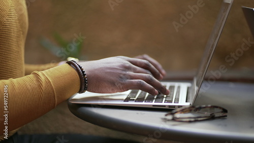Close-up African man hands typing laptop computer keyboard