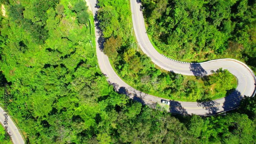 Aerial view above cars driving on winding road in green tropical rainforest. dangerous road. Thailand, Southeast Asia. nature and transportation concept. 4K drone footage
Aerial view above cars driving on winding road in green tropical rainforest. dangerous road. Thailand, Southeast Asia. nature and transportation concept. 4K drone footage