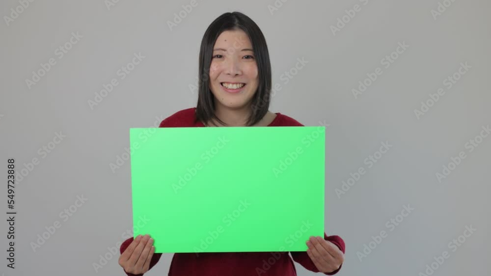 Young asian woman holding green board for chromakey edit. Smiles, Happy, Joy, Delighted. Young asian woman holding green board for chromakey edit. Smiles, Happy, Joy, Delighted.