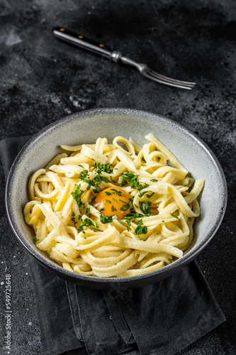 Traditional Bavarian Spaetzle egg Noodles with Butter and Parsley. Black background. Top view