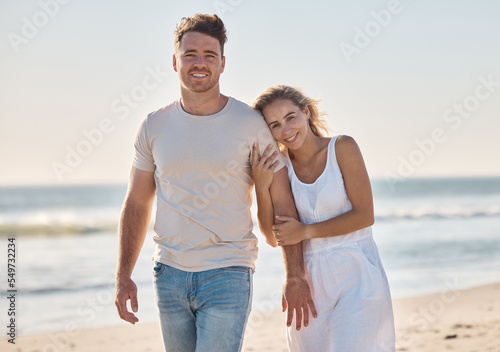 Couple, happy and beach in portrait for love, bonding and walking together on vacation, holiday or honeymoon. Man, woman and romance on adventure, walk or relax by ocean in summer, waves and smile