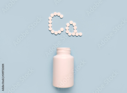 Сhemical element calcium Сa icon from tablets and drug bottle on blue background. Colltction of vitamin and minerals photo