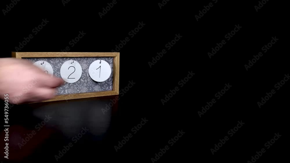 A wooden calendar block showing the date January 21st with a mans hand putting on and taking off the metal discs with the date and month on them, filmed in 4k quality A wooden calendar block showing the date January 21st with a mans hand putting on and taking off the metal discs with the date and month on them, filmed in 4k quality