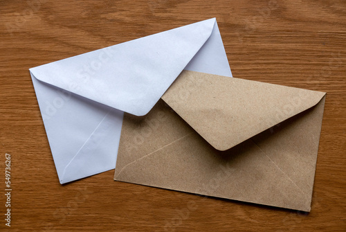 Brown and white envelope on a wooden background.