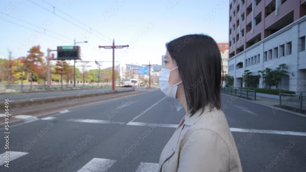 Asian young woman with mask on crossing the street. Oura, Nagasaki. Autumn. Asian young woman with mask on crossing the street. Oura, Nagasaki. Autumn.