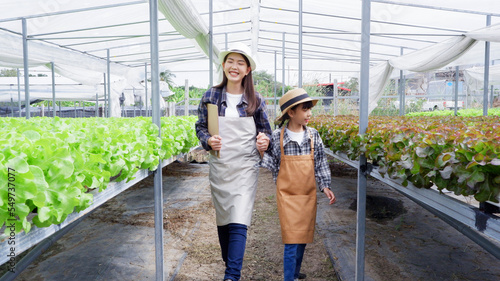 Female gardener inspecting fresh organic vegetable garden organic vegetable garden ideas. © krongthip