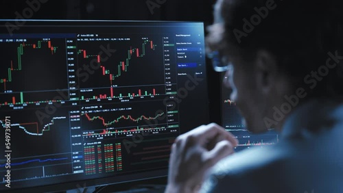 young businessman meditating in front of computer monitors .