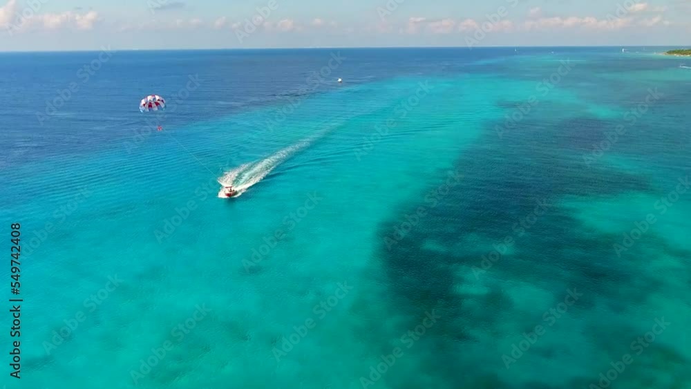 Parasailing aerial view. A couple paraskiing at tropical beach in bright day. Parasailing aerial view. A couple paraskiing at tropical beach in bright day.