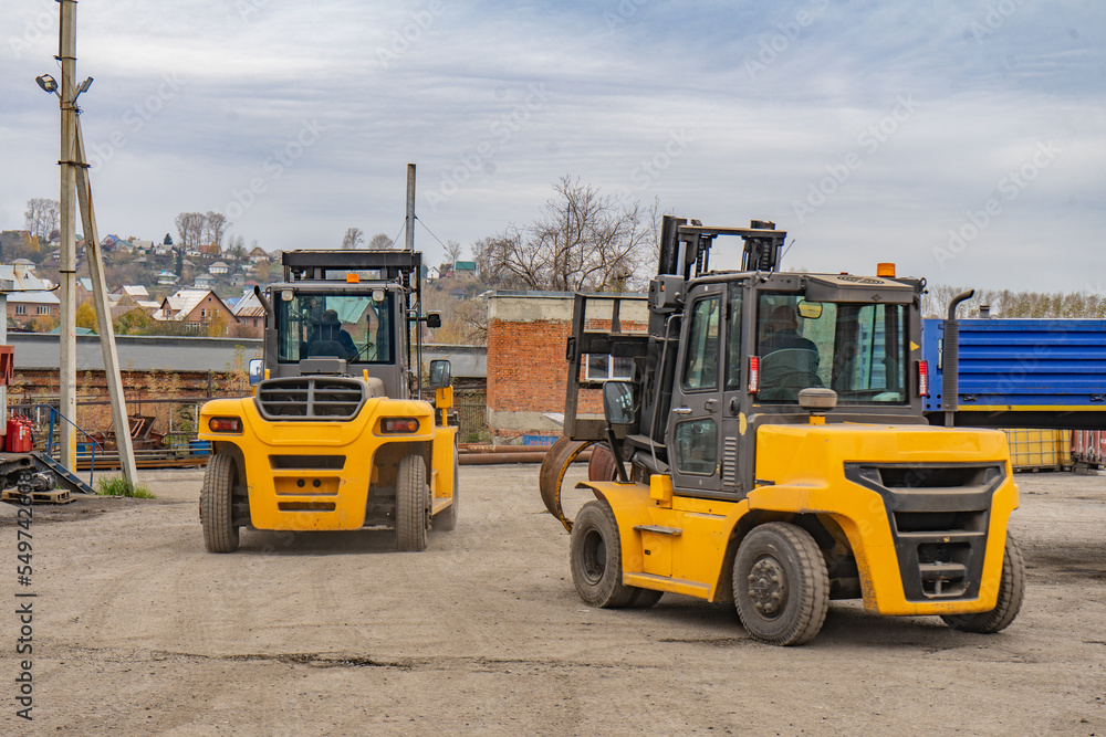 two yellow forklifts while working on cargo transportation. two yellow forklifts while working on cargo transportation.