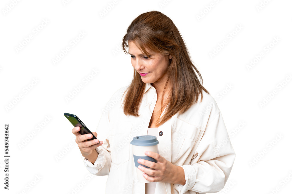 Middle age woman over isolated background holding coffee to take away and a mobile