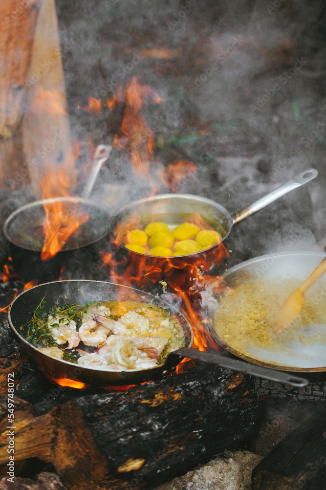 Campfire smoking salmon in pan, near the fire outdoors. bushcraft, adventure, tea, knife and camping concept Campfire smoking salmon in pan, near the fire outdoors. bushcraft, adventure, tea, knife and camping concept