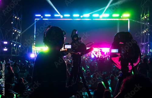 Φωτογραφία Silhouette of the cameraman records and broadcasts live concerts on professional video recording business camcorders