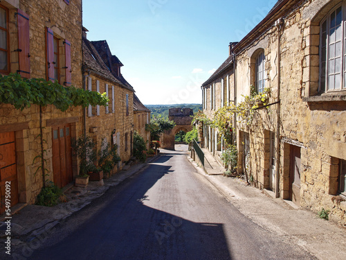 Majestic Bastide of Domme and medieval town of Périgord Noir - Narrow street with old yellow stone perigordian houses before Delbos Gate (Porte de Delbos) photo