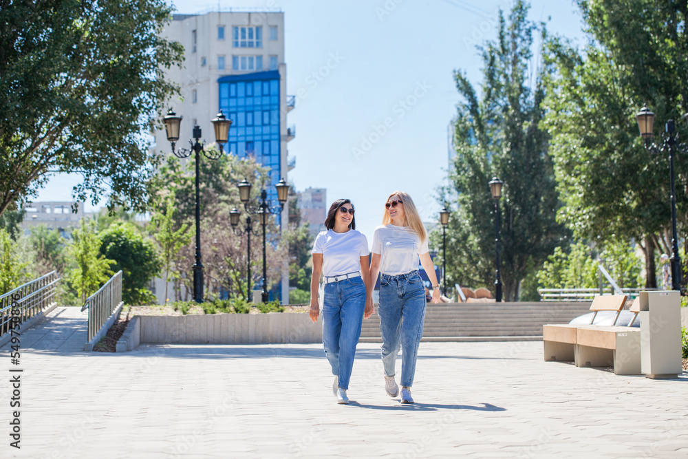 Two women posing against the backdrop of the business center Two women posing against the backdrop of the business center