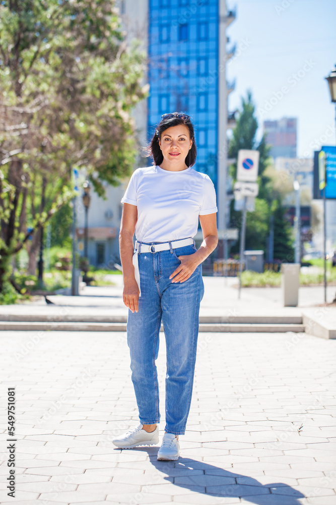 Portrait of middle aged woman in white t-shirt and blue jeans