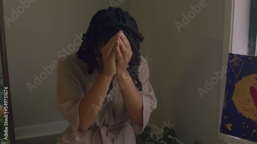Young woman praying in home photo