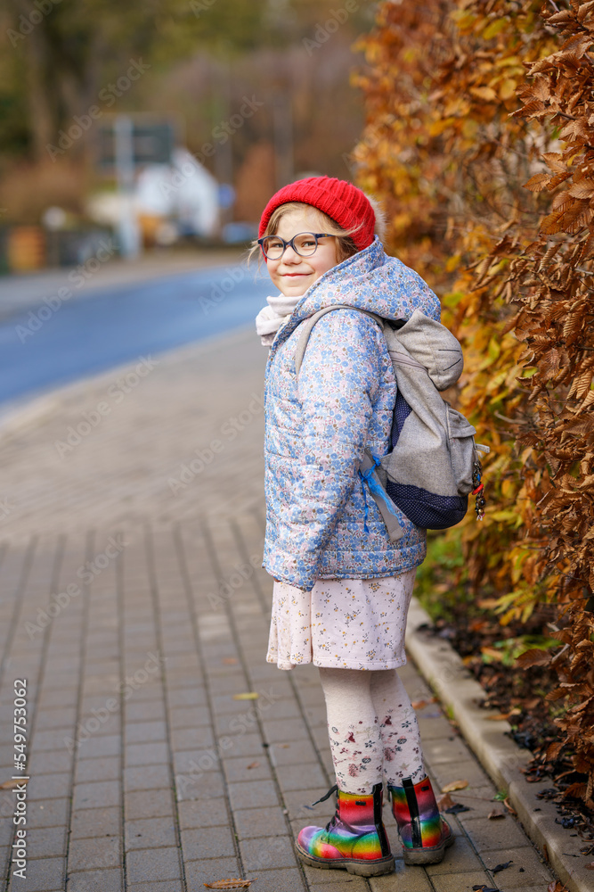 Cute little preschool girl on her the way to playschool. Healthy happy child walking to nursery school. Kindergarten kid with backpack going to day care on the city street, outdoors Cute little preschool girl on her the way to playschool. Healthy happy child walking to nursery school. Kindergarten kid with backpack going to day care on the city street, outdoors