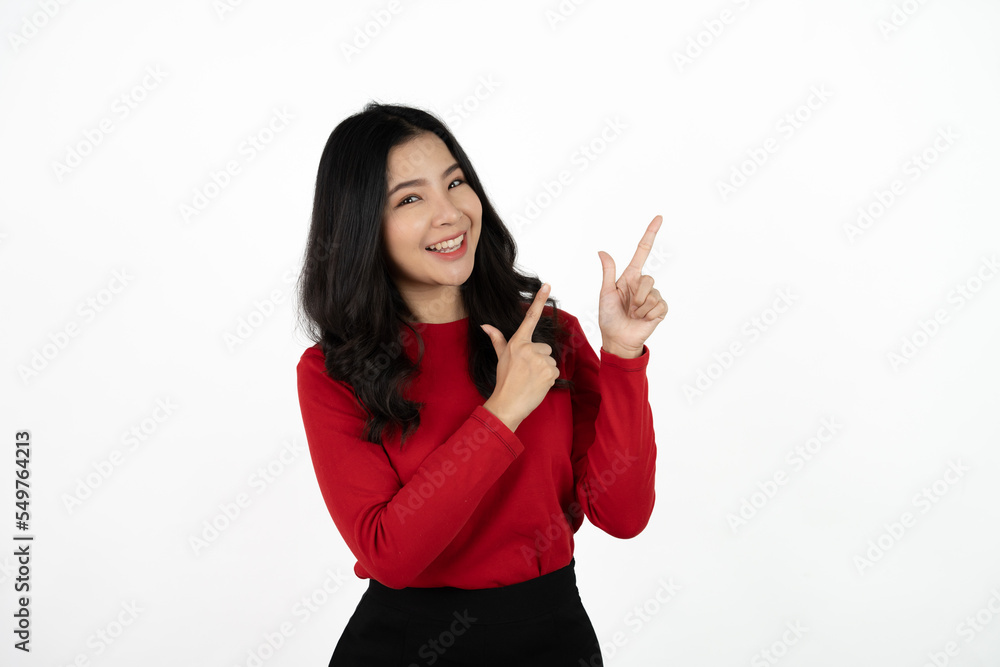 Smiling asian business woman pointing up and looking at the camera over white background. Smiling asian business woman pointing up and looking at the camera over white background.