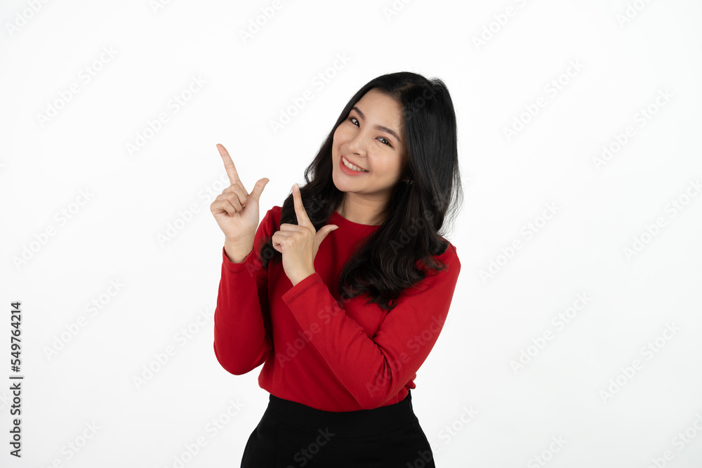 Smiling asian business woman pointing up and looking at the camera over white background. Smiling asian business woman pointing up and looking at the camera over white background.