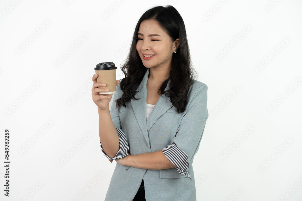 Portrait of a smiling asian businesswoman carrying cup of coffee to go while standing isolated over white background. Portrait of a smiling asian businesswoman carrying cup of coffee to go while standing isolated over white background.