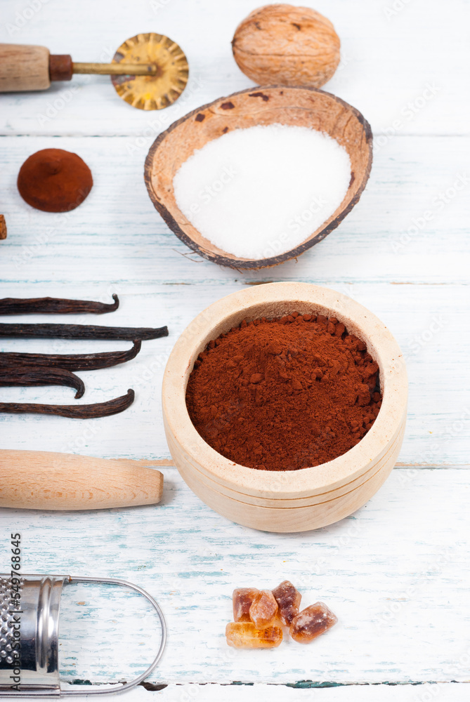 pile of cocoa powder, sugar and dessert ingredients, kitchen utensils on old white wooden pile of cocoa powder, sugar and dessert ingredients, kitchen utensils on old white wooden