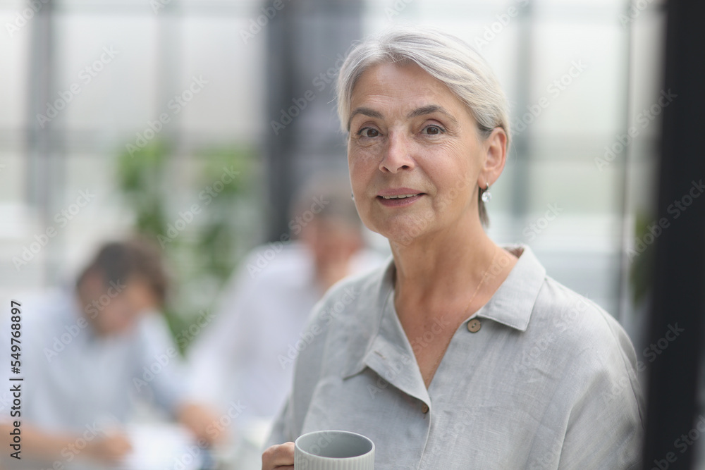 close-up mature woman holding a cup in the office