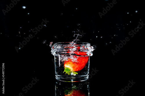 Splash photography capturing an strawberry inside a glass cup