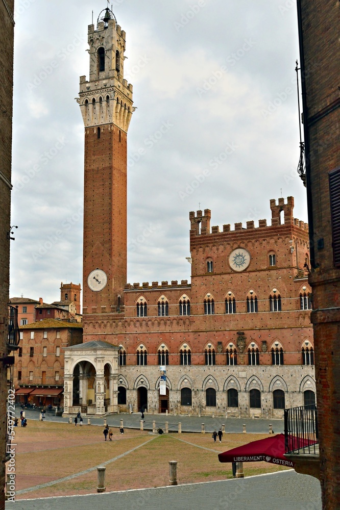 glimpse of Piazza del Campo in the city of Siena in Tuscany, Italy  with the historic Torre del Mangia in the background