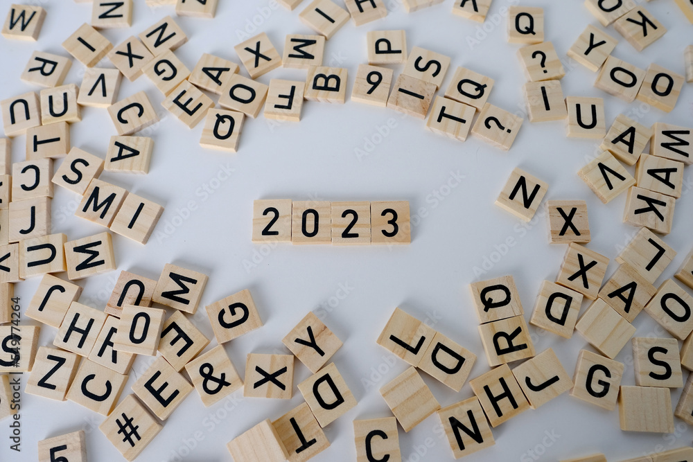Obraz premium close-up of year change calendar with wood cube block tact 2023 on a light table, business concept, last quarter deadline, leave the past, plan for the future