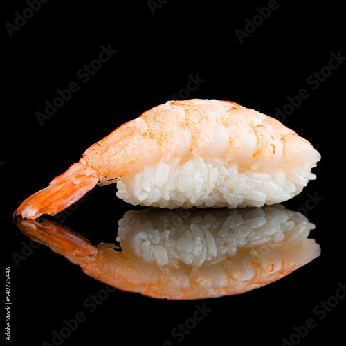 Nigiri sushi with rice and shrimp on black.